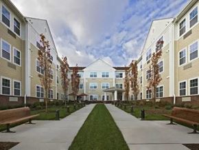 Tinton Falls apartment for rent - a row of buildings with benches and a sidewalk