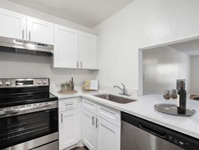 Melbourne apartment for rent - A kitchen with white cabinets and a black oven.