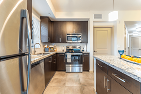 Davie apartment for rent - A modern kitchen with a stainless steel refrigerator and a stove top oven.