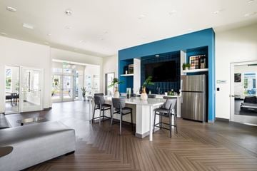 Santa Fe Springs apartment for rent - A modern kitchen with a blue accent wall and a dining table set for two.