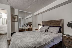 Barrie apartment for rent - A bedroom with a large bed and a mirror on the wall.