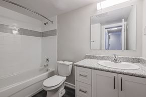 Barrie apartment for rent - A white bathroom with a toilet, sink, and bathtub.