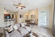 Ocala apartment for rent - A living room with a grey couch and a ceiling fan.