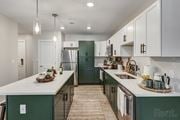 Merrimack apartment for rent - a kitchen with green cabinets and white counters and a stainless steel refrigerator at Edgebrook Residences, Merrimack, NH 03054