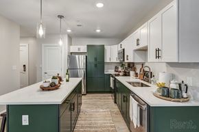 Merrimack apartment for rent - a kitchen with green cabinets and white counters and a stainless steel refrigerator at Edgebrook Residences, Merrimack, NH 03054