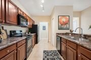 Ocala apartment for rent - A kitchen with brown cabinets and a black refrigerator.
