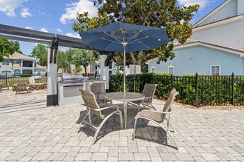 A patio with a table and chairs under an umbrella.
