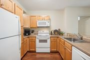 Manchester apartment for rent - a kitchen with wooden cabinets and a white stove and refrigerator at the Residences at Manchester Place in Manchester, New Hampshire