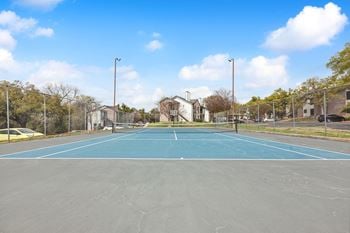 A tennis court with a fence around it on a sunny day