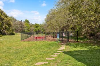 A park with a bench and a chain link fence
