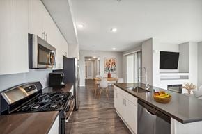 Sparks apartment for rent - a kitchen and living room with a stove and a sink at Lumina at Spanish Springs, Sparks, NV