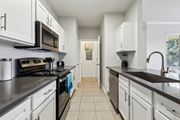 Waco apartment for rent - A Kitchen with Black Countertops at Flats on Chapel Apartments, Waco