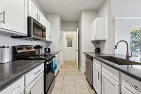 Waco apartment for rent - A Kitchen with Black Countertops at Flats on Chapel Apartments, Waco