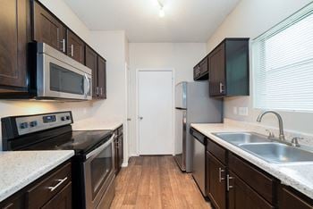 Cherry wood cabinets, upgraded lighting, and stainless steel appliances