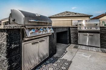 An outdoor kitchen with stainless steel appliances and a grill