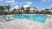 Port St. Lucie apartment for rent - A large swimming pool surrounded by palm trees and lounge chairs. at Lucie at Tradition Apartments, Port St. Lucie, Florida