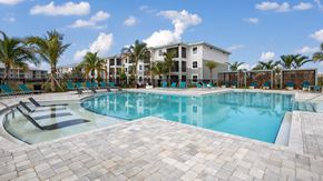 Port St. Lucie apartment for rent - A large swimming pool surrounded by palm trees and lounge chairs. at Lucie at Tradition Apartments, Port St. Lucie, Florida