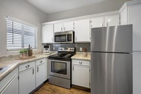 Albuquerque apartment for rent - A modern kitchen with a stainless steel refrigerator, microwave, and oven.