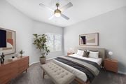 Albuquerque apartment for rent - A bedroom with a large bed, a ceiling fan, and a potted plant.