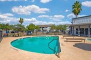 Corpus Christi apartment for rent - A swimming pool surrounded by a fence and a playground.
