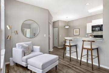 Plant City apartment for rent - A modern living room with a white chair and ottoman.