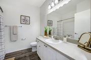 Plant City apartment for rent - A bathroom with a toilet, sink, mirror, and a plant on the counter.