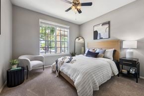 Plant City apartment for rent - A bedroom with a large bed and a window with a view of the street outside.