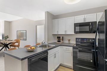 Enfield apartment for rent - A modern kitchen with black appliances and white cabinets.