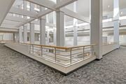 Enfield apartment for rent - A large open space with a carpeted floor and a series of white columns.