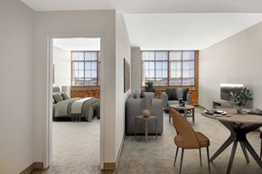 Enfield apartment for rent - A modern living room with an exposed brick wall and a large window.