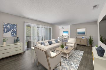 Indialantic apartment for rent - A living room with a white couch, a coffee table, and a painting on the wall.