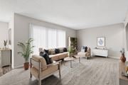 Indialantic apartment for rent - A living room with a beige sofa, a grey rug, and a white wall.