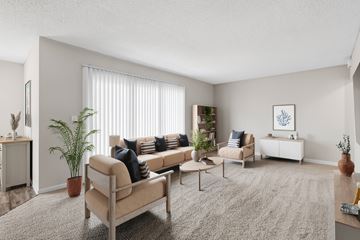 Indialantic apartment for rent - A living room with a beige sofa, a grey rug, and a white wall.