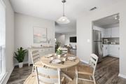 Indialantic apartment for rent - A dining room with a table set for two and a kitchen in the background.