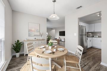 Indialantic apartment for rent - A dining room with a table set for two and a kitchen in the background.
