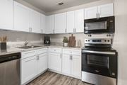 Indialantic apartment for rent - A kitchen with white cabinets and stainless steel appliances.