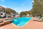 Austin apartment for rent - A swimming pool surrounded by a brick patio and lounge chairs.
