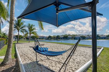 A blue hammock is strung between two poles under a blue canopy.