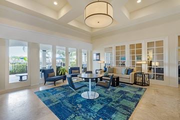 Fort Myers apartment for rent - A spacious living room with a blue rug and a large window.