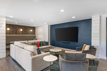 Alpharetta apartment for rent - A modern living room with a grey sofa and a large television.