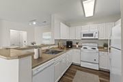 Quincy apartment for rent - A white kitchen with a stove, microwave, and refrigerator.
