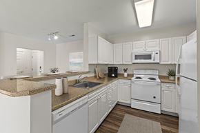 Quincy apartment for rent - A white kitchen with a stove, microwave, and refrigerator.