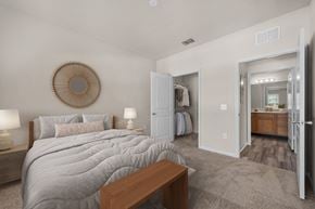 Orange City apartment for rent - A bedroom with a large bed and a wooden bench.