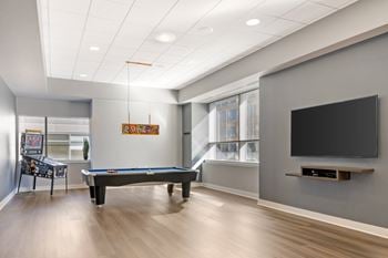 A room with a pool table and a television.