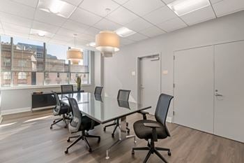 A conference room with a glass table and chairs.