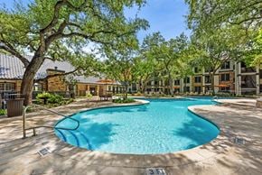 Austin apartment for rent - A swimming pool surrounded by trees and buildings.