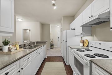 Austin apartment for rent - A modern kitchen with white cabinets and appliances.