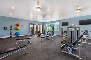 Tucson apartment for rent - A gym with a variety of equipment including weights and exercise machines.