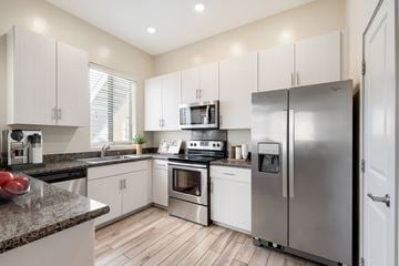 Tucson apartment for rent - A modern kitchen with stainless steel appliances and white cabinets.