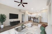 Tucson apartment for rent - A modern living room with a flat screen TV, a coffee table, and a ceiling fan.